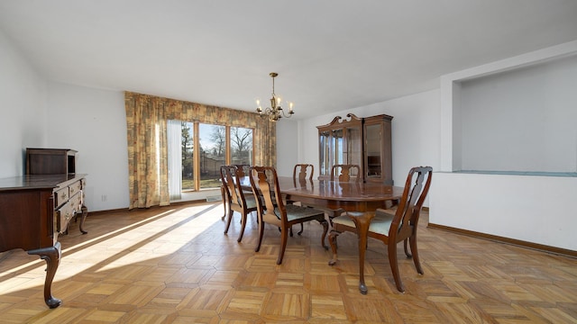 dining area featuring baseboards and a chandelier