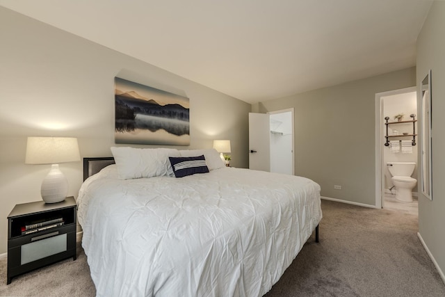 carpeted bedroom featuring a closet, baseboards, a walk in closet, and connected bathroom