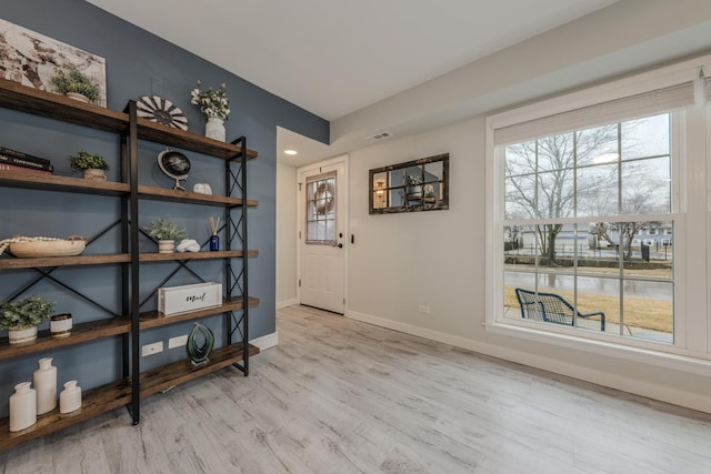 interior space with visible vents, light wood-style flooring, and baseboards