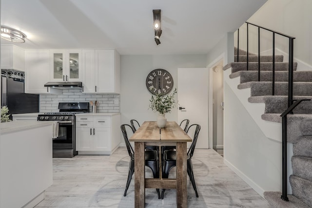 dining room featuring light wood-style floors and stairway