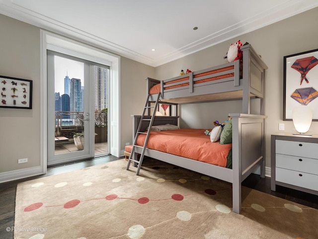 bedroom with a city view, crown molding, wood finished floors, access to outside, and baseboards