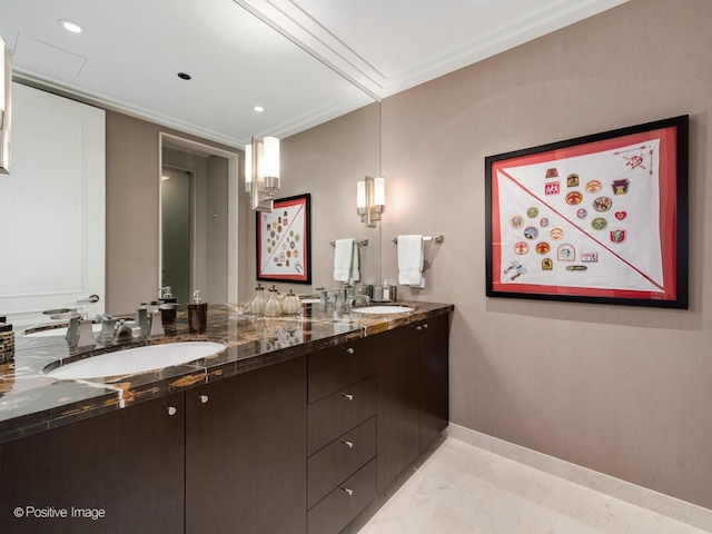 bathroom featuring marble finish floor, a sink, baseboards, and double vanity