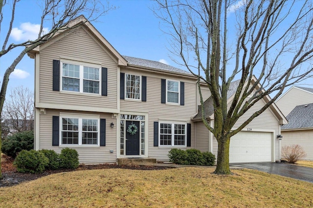 view of front facade featuring a garage, aphalt driveway, and a front yard