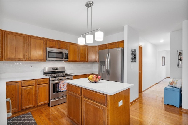 kitchen featuring light wood-style flooring, appliances with stainless steel finishes, light countertops, and backsplash