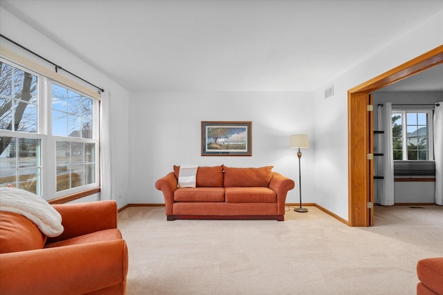 carpeted living room with plenty of natural light, visible vents, and baseboards