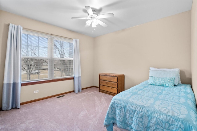 carpeted bedroom featuring a ceiling fan, visible vents, and baseboards