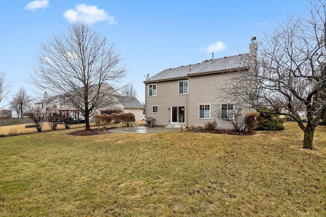 back of house with a patio area, a chimney, and a lawn