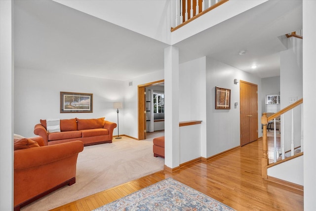 living room with stairs, baseboards, and wood finished floors