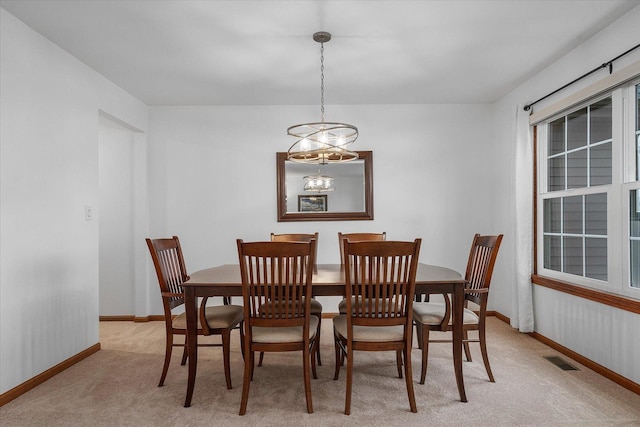 dining room with light carpet, baseboards, and visible vents