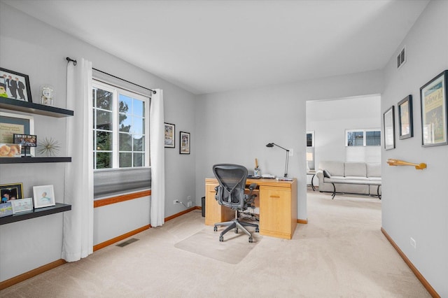 carpeted office space featuring visible vents and baseboards