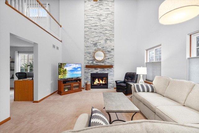 living room with carpet floors, visible vents, a fireplace, and baseboards