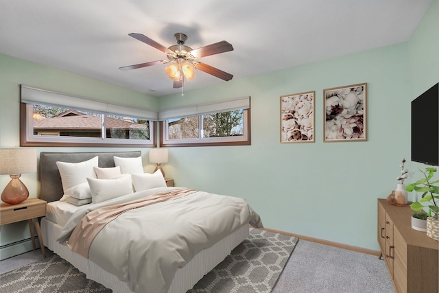 carpeted bedroom with ceiling fan, baseboards, and baseboard heating