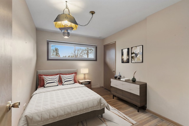 bedroom with light wood-style flooring and baseboards