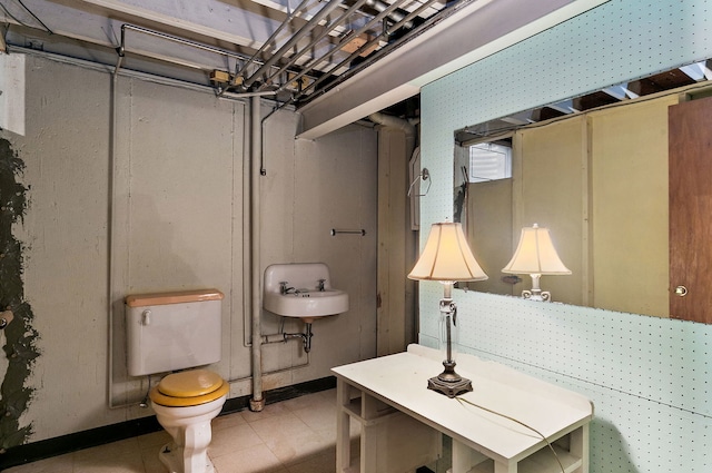 bathroom featuring toilet, a sink, and tile patterned floors