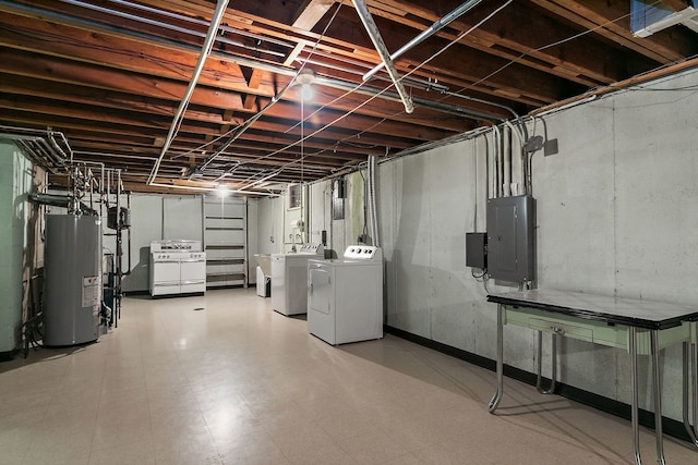 unfinished below grade area featuring separate washer and dryer, gas water heater, electric panel, and tile patterned floors