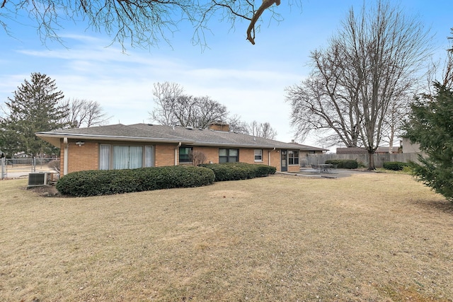 back of property with brick siding, a lawn, a patio area, fence, and cooling unit