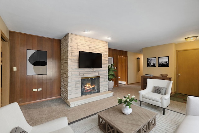 carpeted living area with a stone fireplace and wood walls