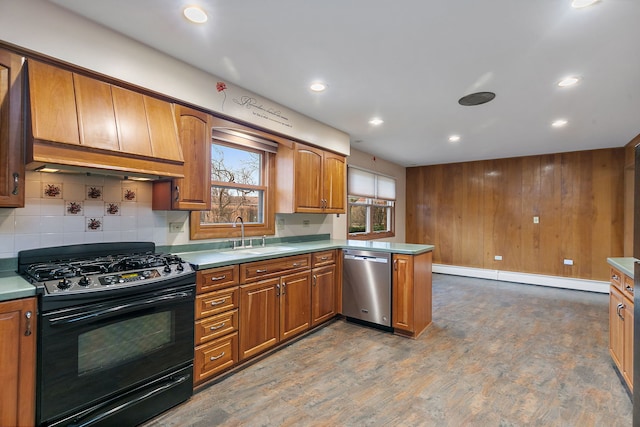 kitchen with black gas range, a peninsula, a sink, baseboard heating, and dishwasher