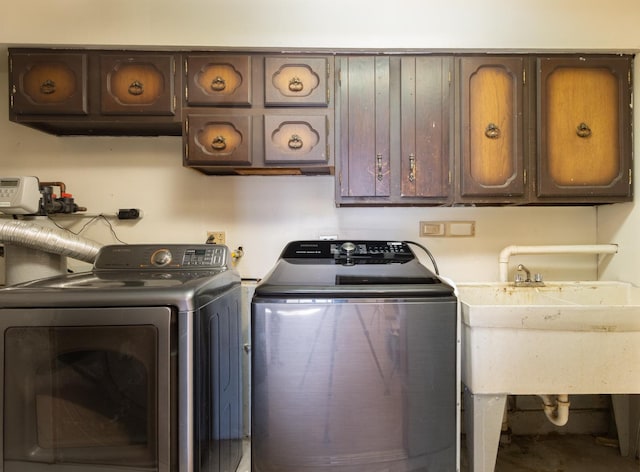 laundry area featuring washer and clothes dryer, a sink, and cabinet space