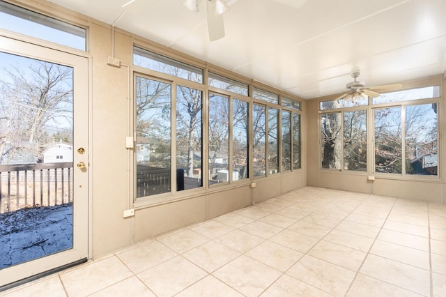 unfurnished sunroom featuring ceiling fan