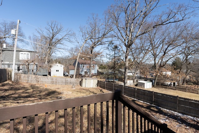 view of yard featuring a storage shed, a fenced backyard, and an outbuilding