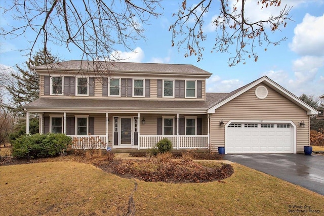 view of front of property featuring a shingled roof, covered porch, a garage, driveway, and a front lawn