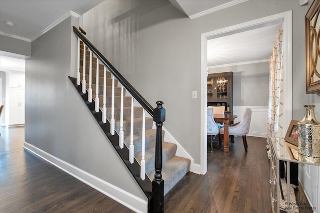 stairs with crown molding, baseboards, and wood finished floors