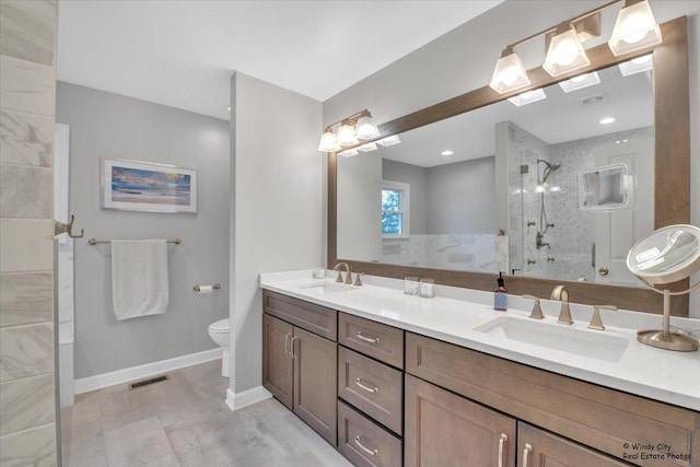 full bath featuring tiled shower, a sink, toilet, and baseboards