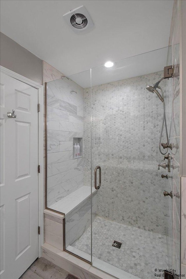 full bath with a shower stall and visible vents