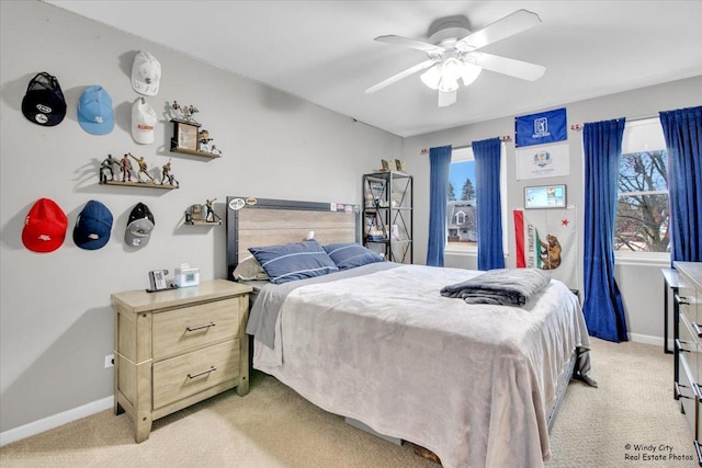 bedroom featuring light carpet, ceiling fan, and baseboards