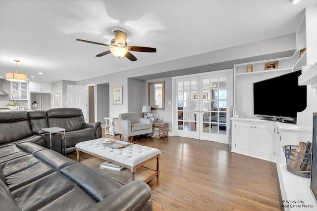 living room featuring a ceiling fan, french doors, and wood finished floors