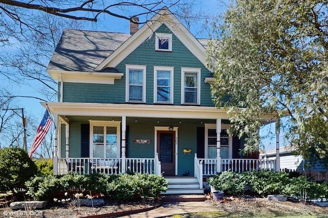 victorian home featuring a porch and a chimney