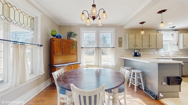 dining room featuring a chandelier, light wood-type flooring, baseboards, and ornamental molding