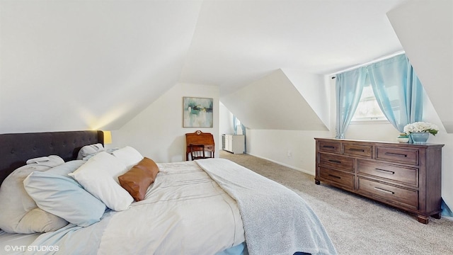 bedroom with baseboards, light carpet, and lofted ceiling