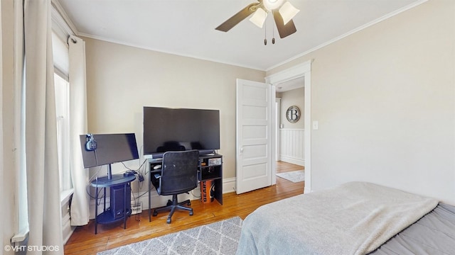 bedroom with hardwood / wood-style flooring, crown molding, and ceiling fan