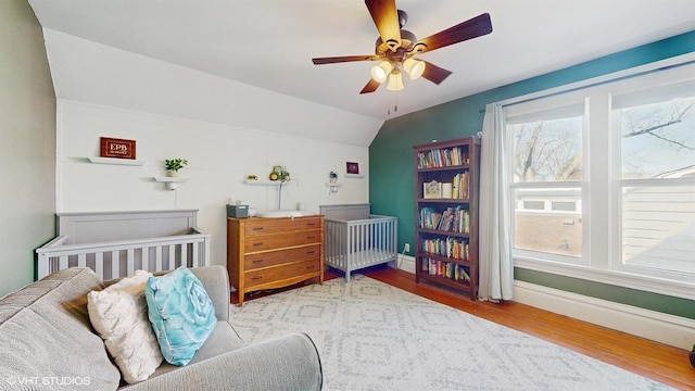 bedroom featuring lofted ceiling, wood finished floors, and baseboards