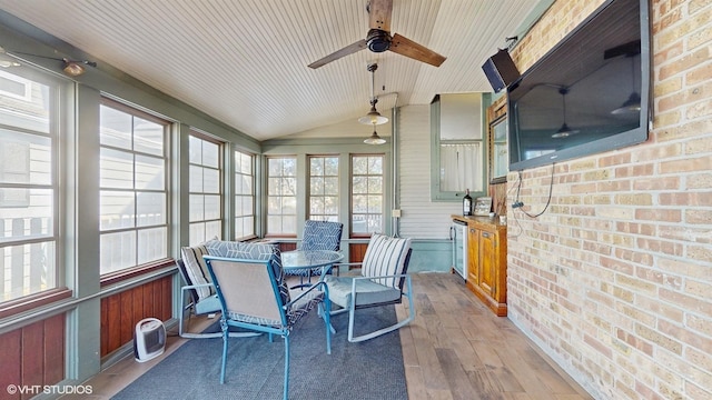 sunroom / solarium with wine cooler, a ceiling fan, and lofted ceiling