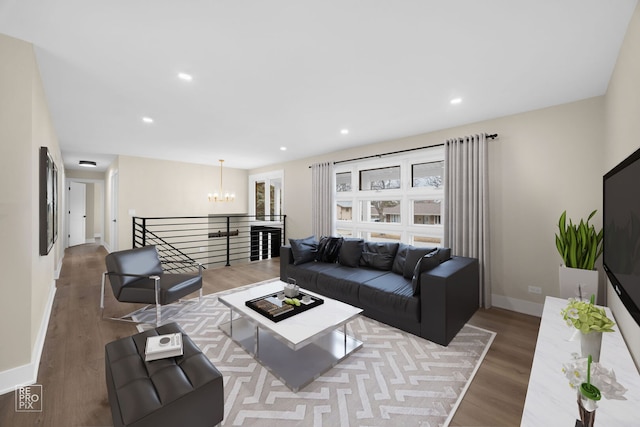 living area featuring recessed lighting, baseboards, an inviting chandelier, and wood finished floors