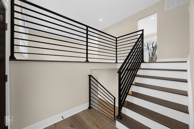 stairway featuring recessed lighting, wood finished floors, visible vents, and baseboards