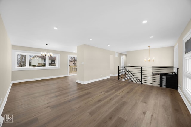 spare room with recessed lighting, a notable chandelier, and wood finished floors