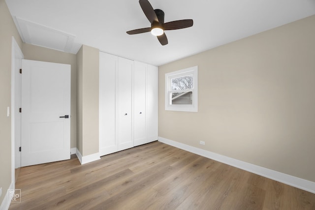 unfurnished bedroom with a closet, baseboards, light wood-style floors, and a ceiling fan