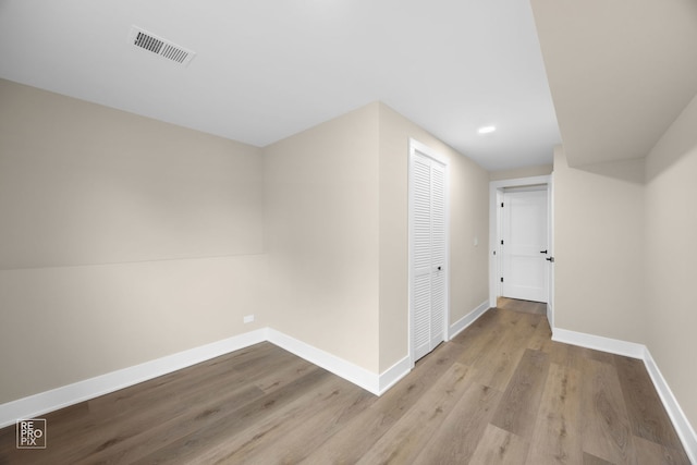 unfurnished room featuring visible vents, baseboards, and wood finished floors