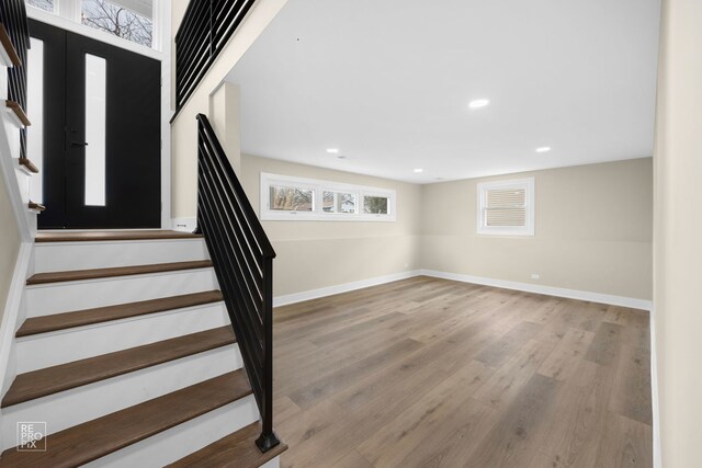 interior space with stairs, recessed lighting, wood finished floors, and baseboards