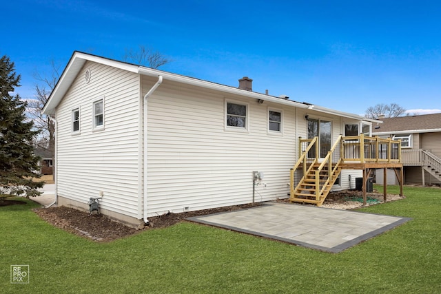 rear view of house featuring a wooden deck, stairs, a lawn, a chimney, and a patio area