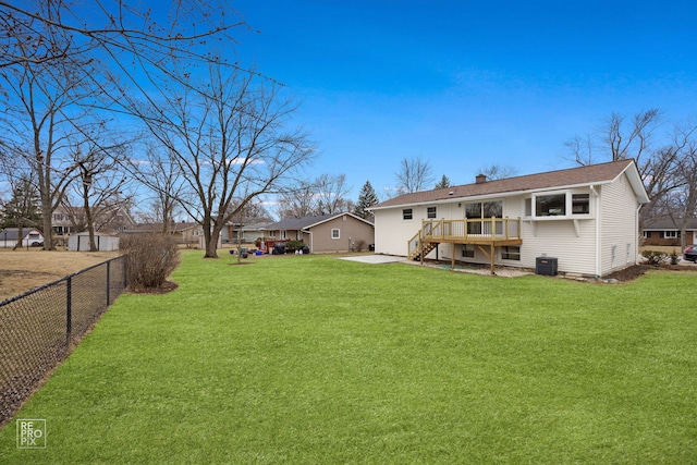 rear view of house featuring a deck, fence, a yard, central AC unit, and a chimney