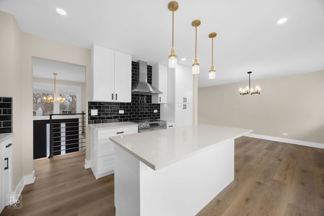 kitchen featuring tasteful backsplash, stainless steel range, wall chimney exhaust hood, and an inviting chandelier