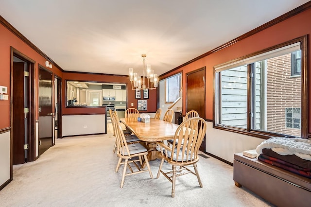 dining area with baseboards, light carpet, a chandelier, and ornamental molding