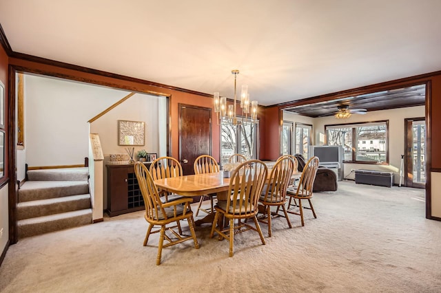 dining area with stairway, ceiling fan with notable chandelier, crown molding, and carpet floors