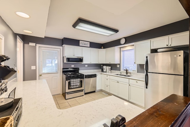 kitchen with a sink, light tile patterned floors, white cabinetry, and stainless steel appliances