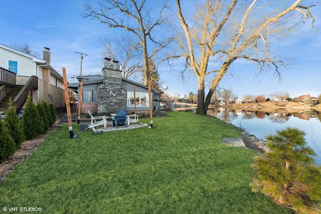 view of yard with a water view, stairs, and a patio area